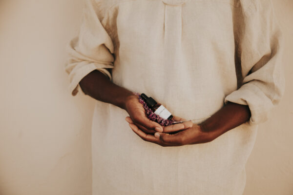 Hands holding the bottle of calm moon menstrual relief oil